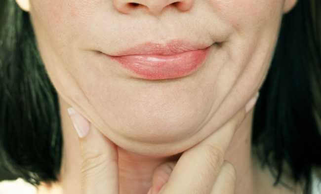 A woman grabbing her double chin fat